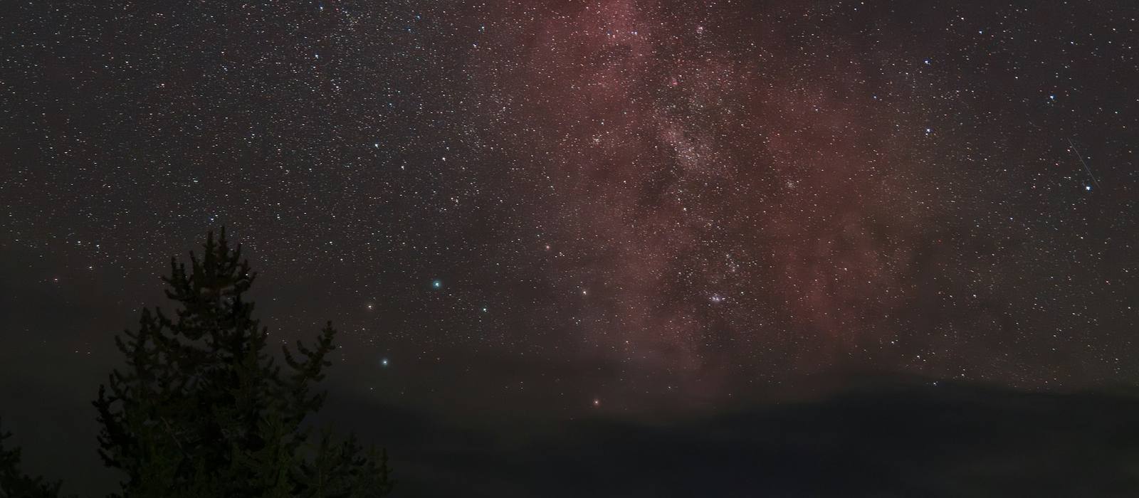 A lit tent glowing beneath the Milky Way