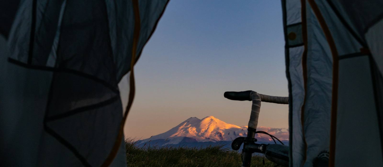 View of a mountain at dusk through an open tent door